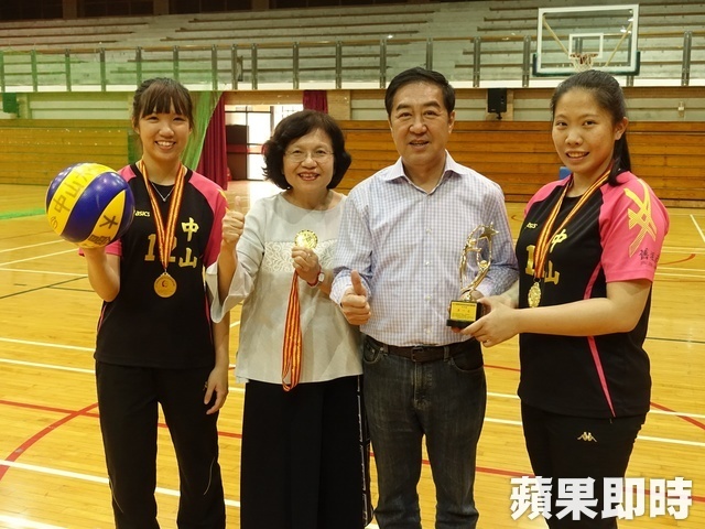 中山大學女排隊員楊子琳（左一）與簡鸝樺（右一）獻獎給副校長蔡秀芬（左二）及舊振南食品董事長李雄慶（左三）。翻攝畫面圖片
