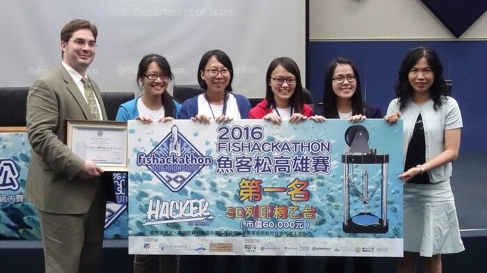 「魚客松（Fishackathon）」高雄場競賽由4名女性工程師組成的團隊「We could fish」奪冠，AIT高雄分處文化新聞組組長陳漢藝（左一）及 高雄市自造者發展協會董事長魏米凰（右一）頒發價值6萬元的3D列印機給獲獎團隊。圖片