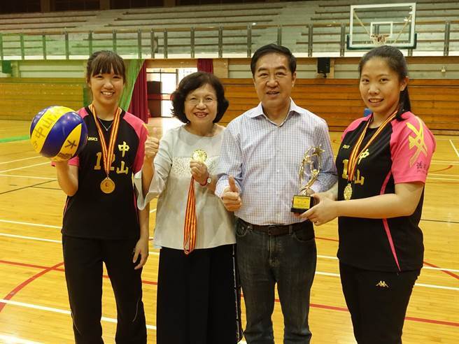 中山大學女排清寒生楊子琳(左一)與簡鸝樺(右一)參加兩岸四地比賽摘金，獻獎給副校長蔡秀芬(左二)及舊振南食品公司董事長李雄慶(左三)。(中山大學提供)圖片