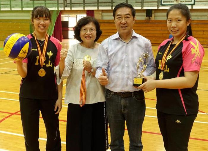 中山大學女排清寒生楊子琳(左一)、簡鸝樺(右一)代表獻獎給副校長蔡秀芬(左二)、舊振南食品公司董事長李雄慶(左三)。圖／中山大學提供圖片